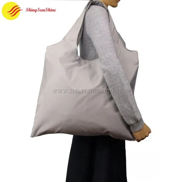 Eco-friendly polyester tote bag with custom branding, photographed in lifestyle setting