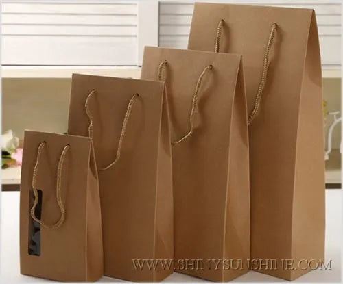 Set of brown paper bags with handles on a white surface