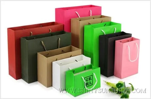 Collection of colorful paper bags on a white background with a visible website address.